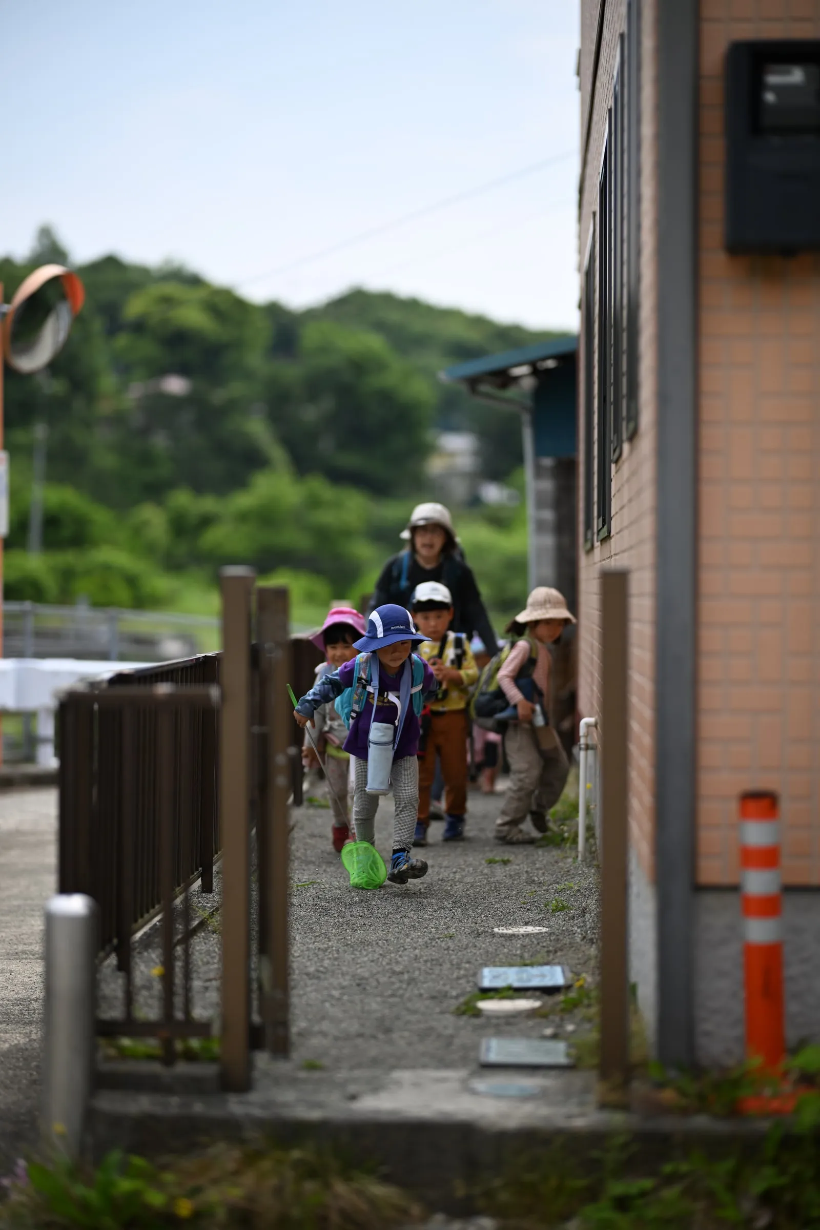 建物のそばを歩いていく子どもたち