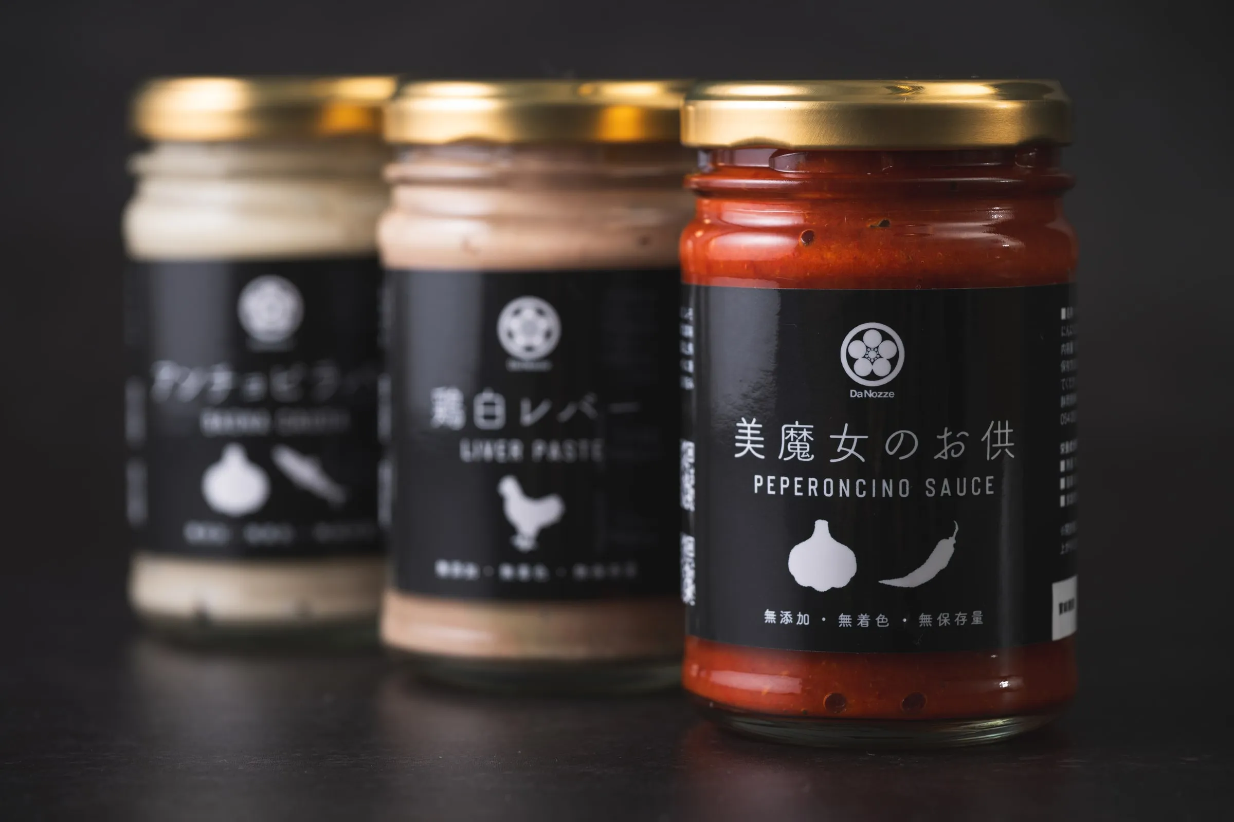 暗い背景に並ぶDanozzeの瓶入り商品