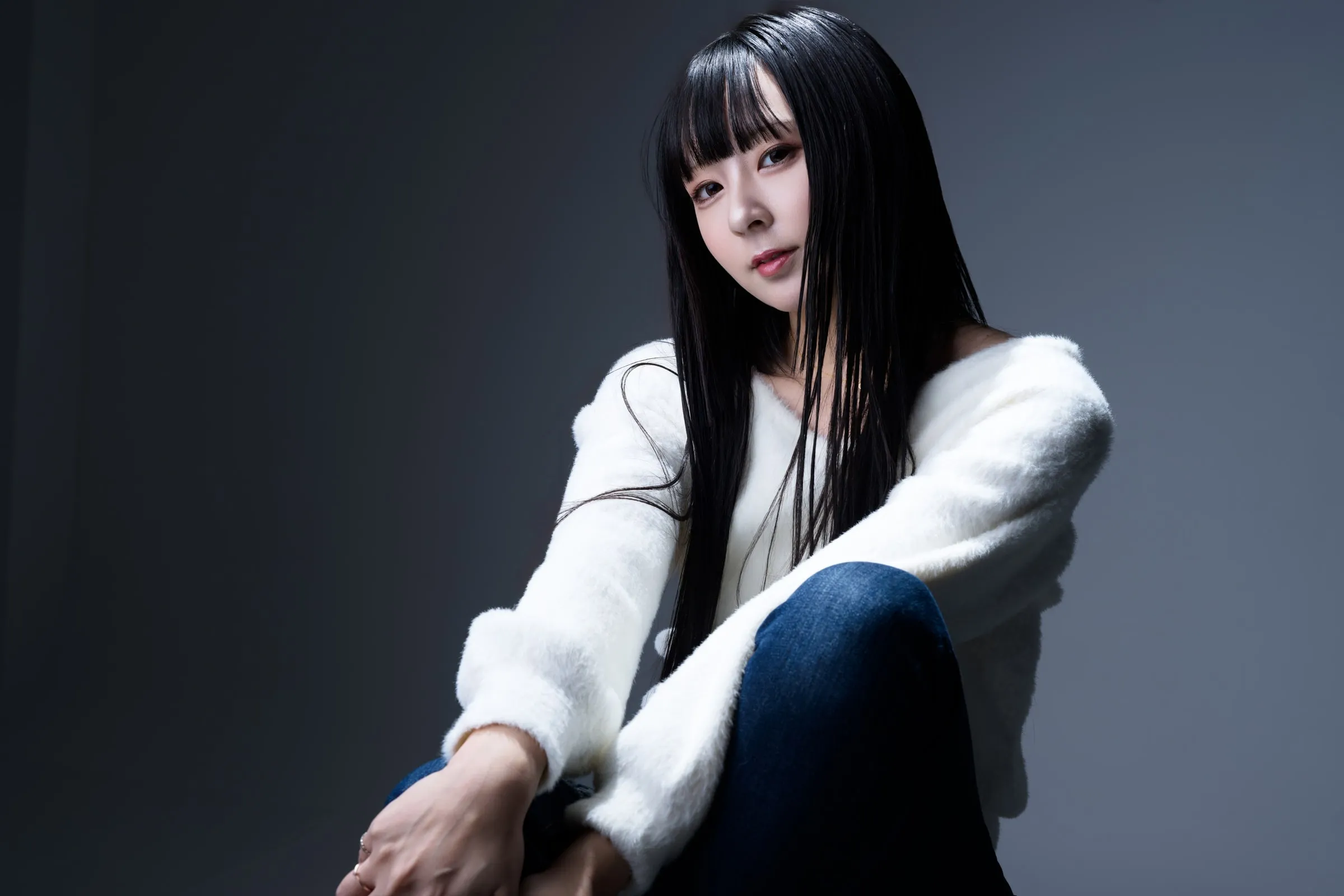 暗い背景で白い服を着たモデルのレンズ作例